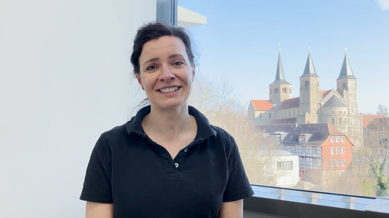Kollegin Katja vor dem Fenster mit Blick auf Hildesheim